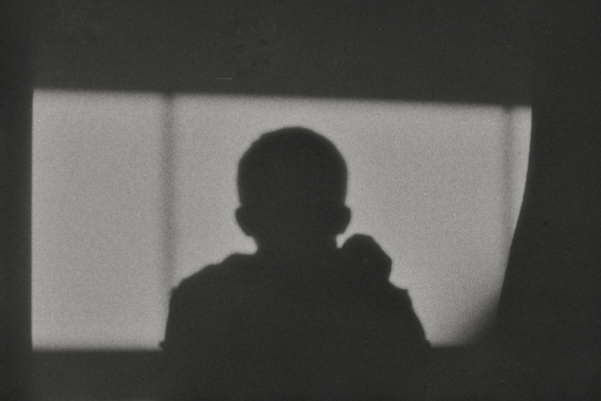 A horizontal black and white photograph of the shadow of my head cast onto a rectangle of light.