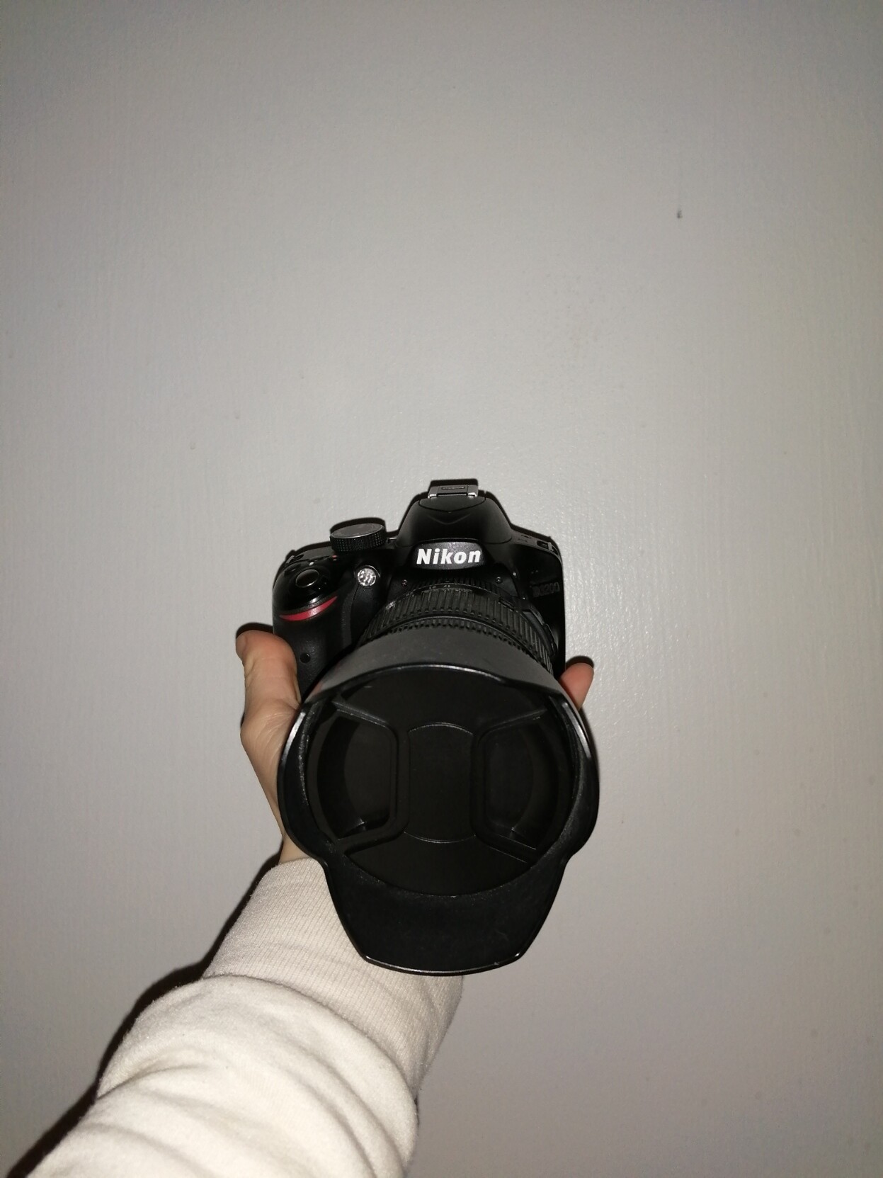 A Hand holding a digital camera against a white background